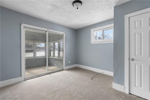 empty room with a textured ceiling and carpet flooring