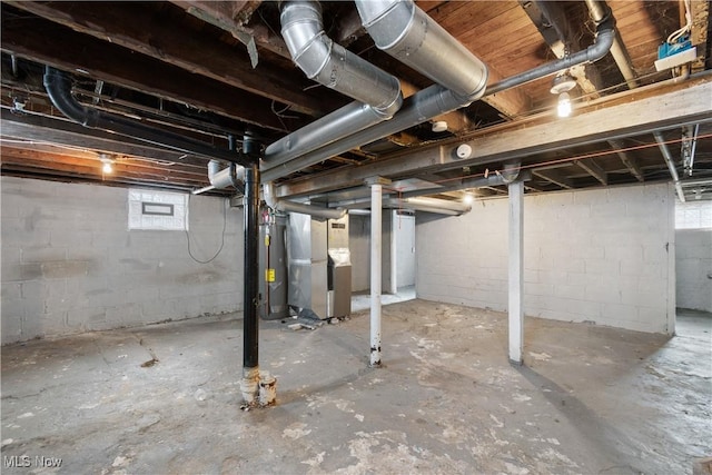 basement with water heater, a healthy amount of sunlight, and heating unit