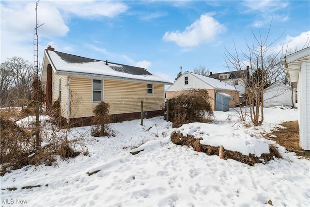 view of snow covered rear of property