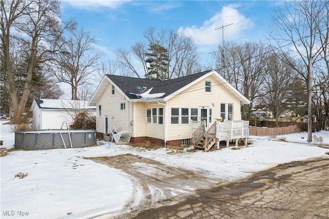 snow covered rear of property with a deck