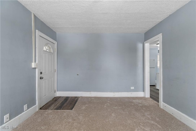 carpeted foyer featuring a textured ceiling