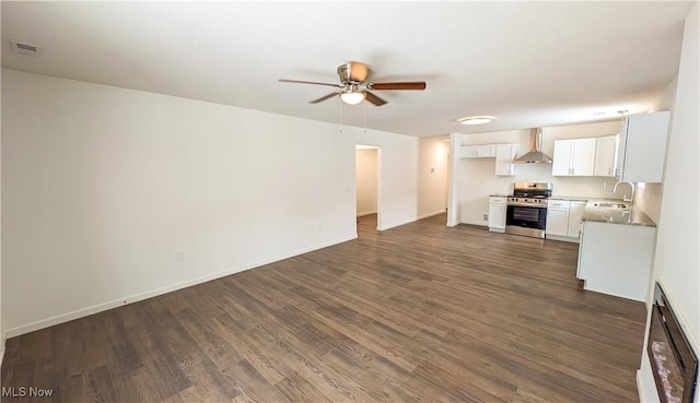 unfurnished living room with dark wood-type flooring, ceiling fan, and sink