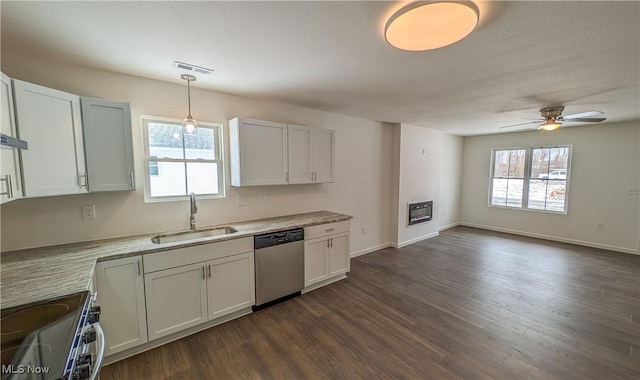 kitchen with hanging light fixtures, appliances with stainless steel finishes, sink, and white cabinets