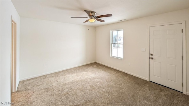 spare room featuring light colored carpet and ceiling fan