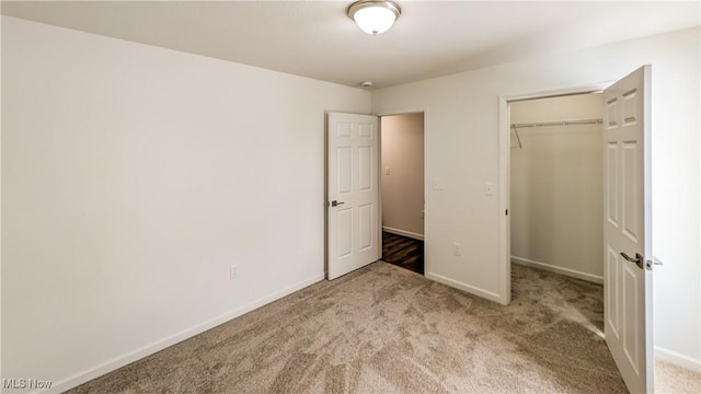 unfurnished bedroom with light carpet and a closet