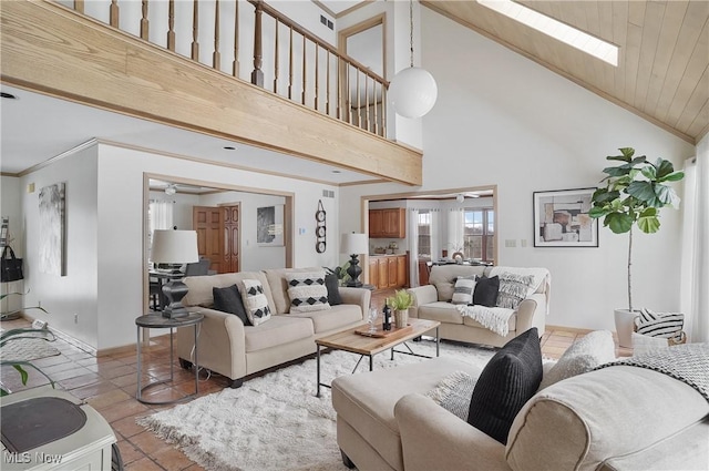 living room featuring ornamental molding, a skylight, and light tile patterned floors