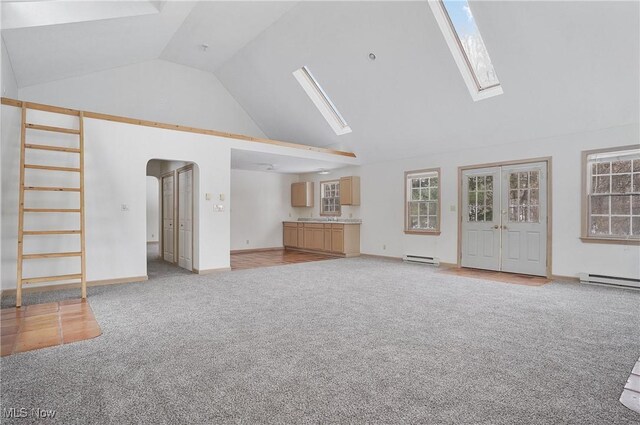 unfurnished living room featuring high vaulted ceiling, a skylight, and light colored carpet