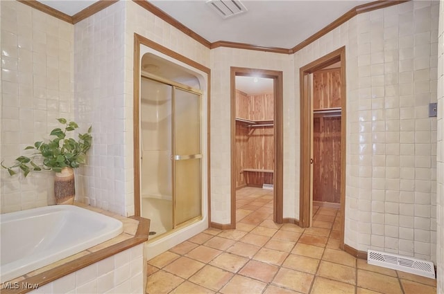 bathroom with tile walls, crown molding, tile patterned floors, and separate shower and tub