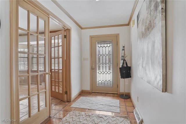 entryway with ornamental molding and light tile patterned floors