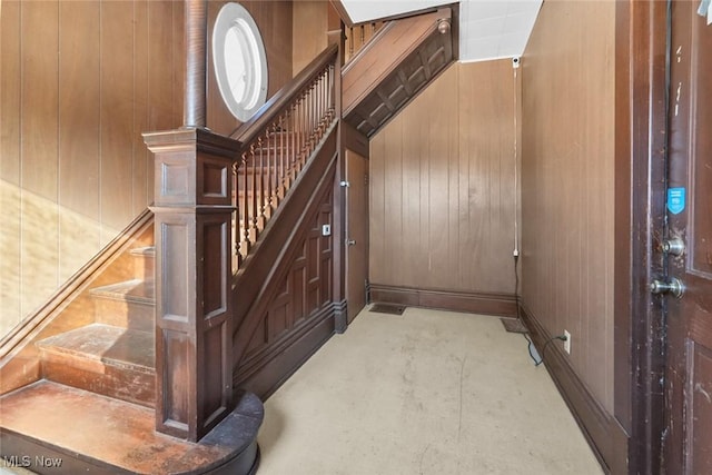 stairs featuring wood walls