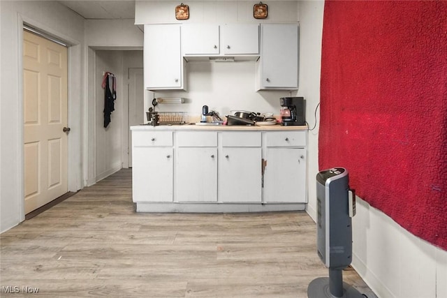 kitchen with white cabinetry, light hardwood / wood-style floors, and sink