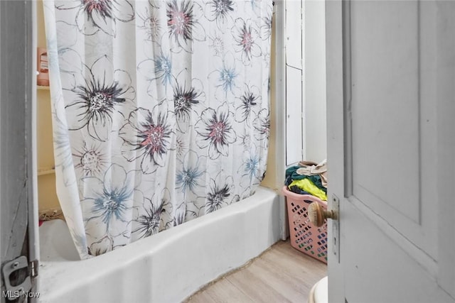 bathroom with hardwood / wood-style flooring and shower / tub combo