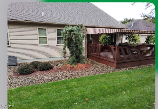 rear view of house featuring a yard and central AC unit