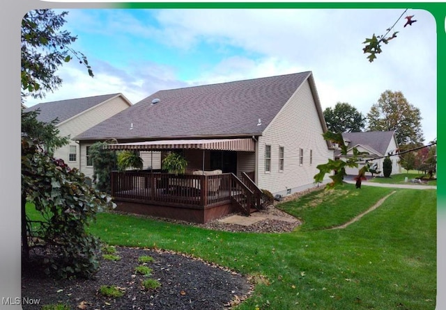 rear view of property with a wooden deck and a lawn