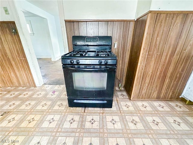 3235 W 94th St, Cleveland, OH 44102 - kitchen featuring black range with gas stovetop and wood walls