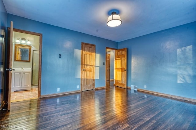 unfurnished bedroom with dark hardwood / wood-style flooring