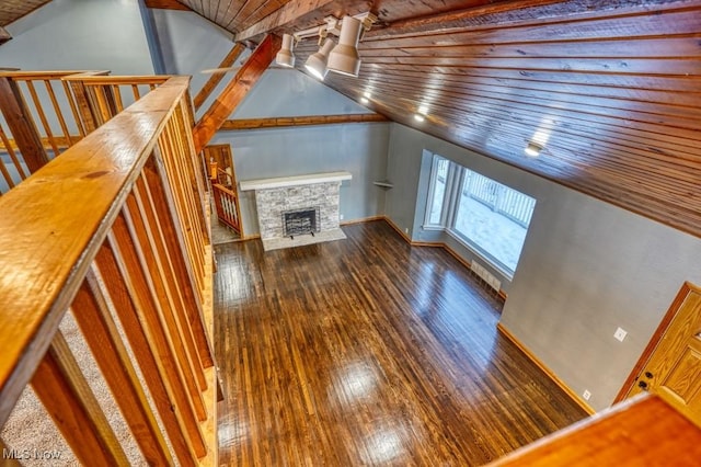 unfurnished living room featuring vaulted ceiling with beams, wood ceiling, a stone fireplace, and dark wood-type flooring