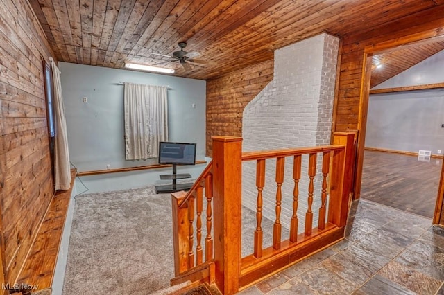 stairs featuring ceiling fan and brick wall