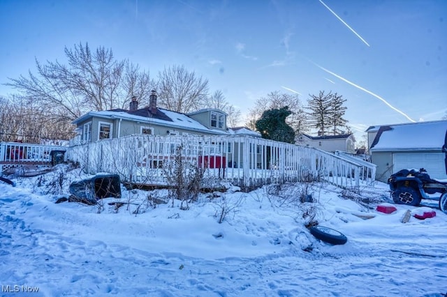 snow covered house featuring a wooden deck