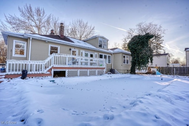 snow covered house featuring a wooden deck