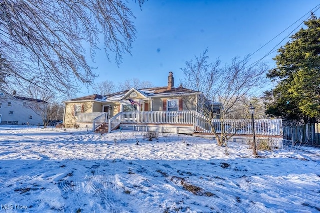 snow covered house featuring a porch