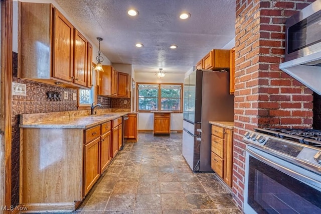 kitchen featuring tasteful backsplash, sink, hanging light fixtures, light stone counters, and stainless steel appliances