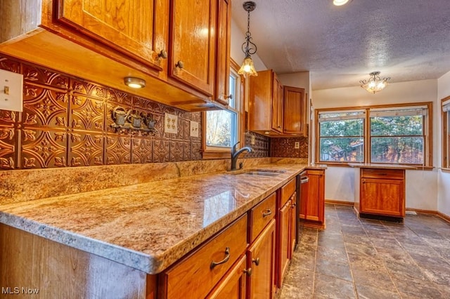 kitchen with sink, decorative light fixtures, stainless steel dishwasher, light stone countertops, and backsplash