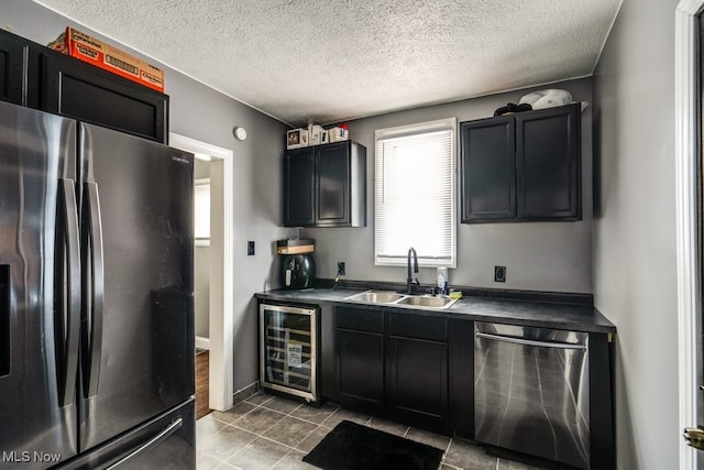 kitchen with sink, tile patterned floors, fridge, wine cooler, and stainless steel dishwasher