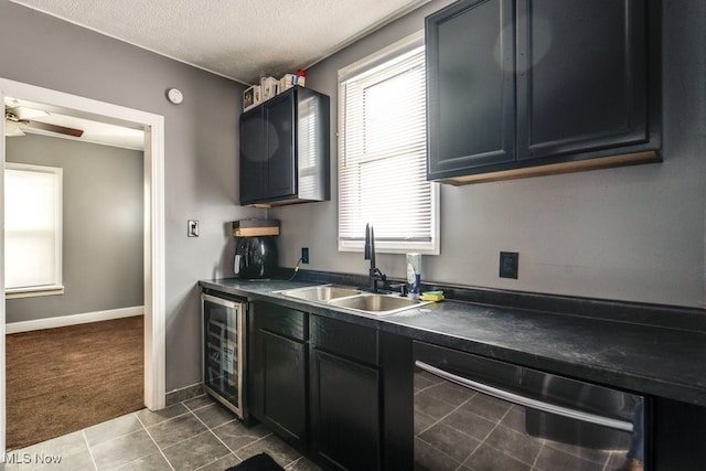 kitchen with sink, dishwasher, ceiling fan, a textured ceiling, and beverage cooler