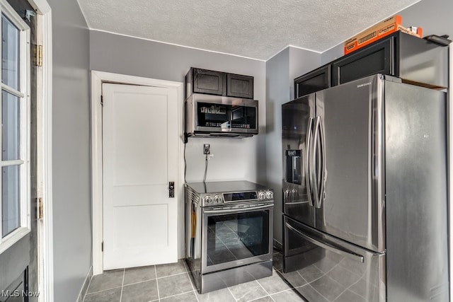 kitchen with stainless steel appliances, light tile patterned floors, and a textured ceiling