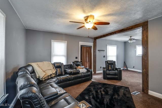 living room with ceiling fan, a textured ceiling, and carpet flooring