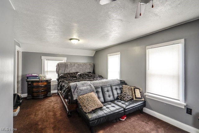 bedroom with lofted ceiling, dark carpet, and multiple windows