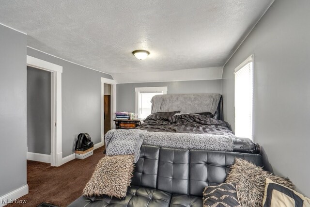 carpeted bedroom with multiple windows and a textured ceiling