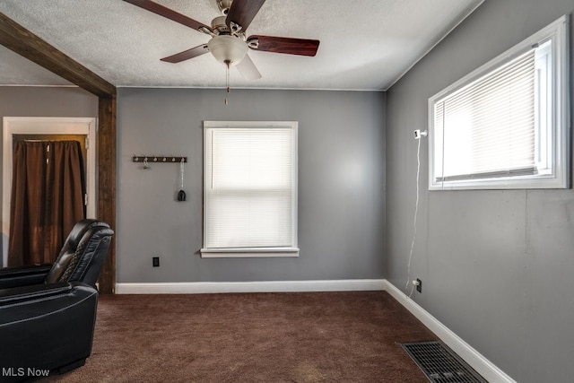 home office with ceiling fan, a textured ceiling, and dark colored carpet