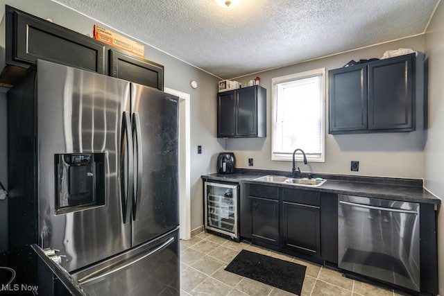 2743 12th St SW, Canton, OH 44710 - kitchen featuring appliances with stainless steel finishes, beverage cooler, a sink, dark countertops, and a textured ceiling