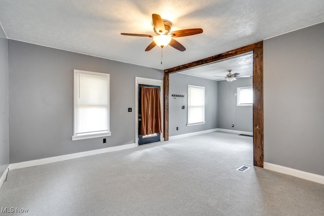 2743 12th St SW, Canton, OH 44710 - empty room featuring ceiling fan, baseboards, light colored carpet, a textured ceiling, and beam ceiling