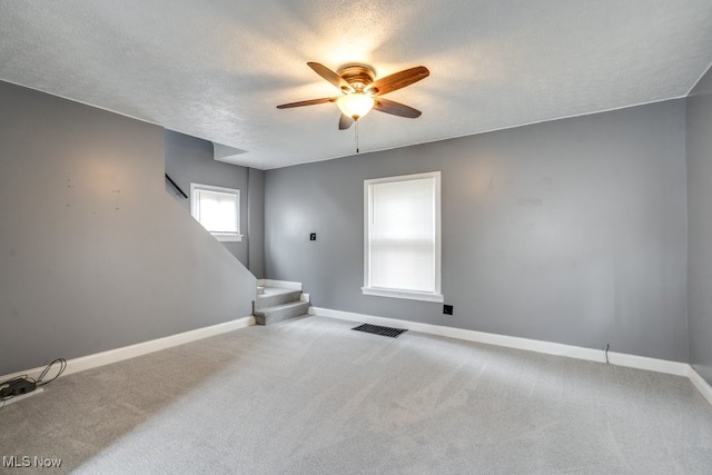 2743 12th St SW, Canton, OH 44710 - carpeted empty room featuring a ceiling fan, baseboards, stairway, and a textured ceiling