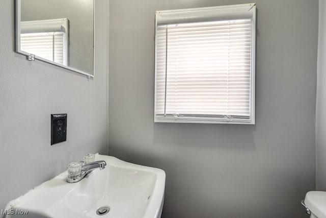 2743 12th St SW, Canton, OH 44710 - half bathroom with a sink, toilet, and healthy amount of natural light