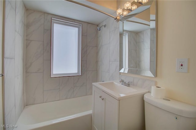 full bathroom featuring tiled shower / bath, vanity, toilet, and a chandelier