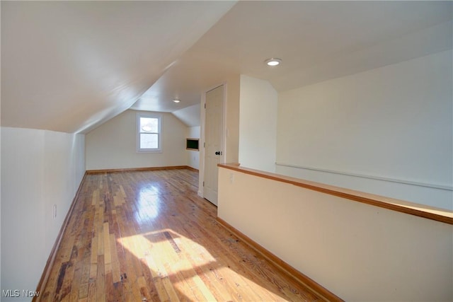 additional living space with lofted ceiling and light hardwood / wood-style floors