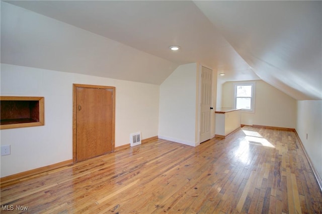 bonus room featuring lofted ceiling and light hardwood / wood-style floors