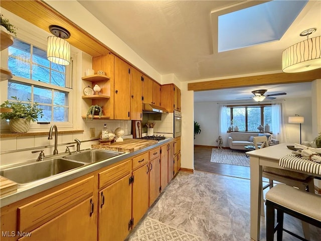 kitchen with a sink, backsplash, pendant lighting, stainless steel appliances, and open shelves