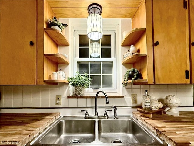 kitchen featuring a sink, backsplash, and open shelves