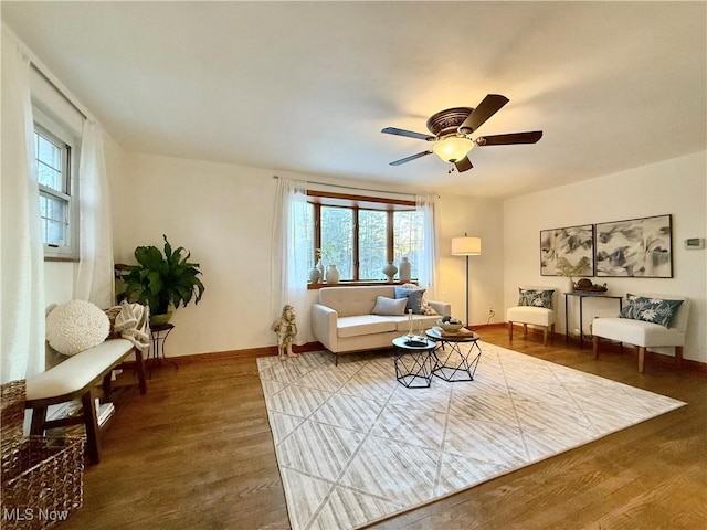 living room featuring a ceiling fan, wood finished floors, and baseboards