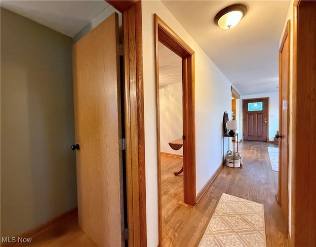 hall featuring wood finished floors and baseboards