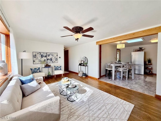 living room featuring a ceiling fan, wood finished floors, and baseboards