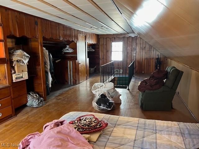 interior space with lofted ceiling and wood walls