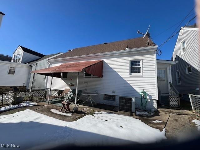 snow covered house with central air condition unit