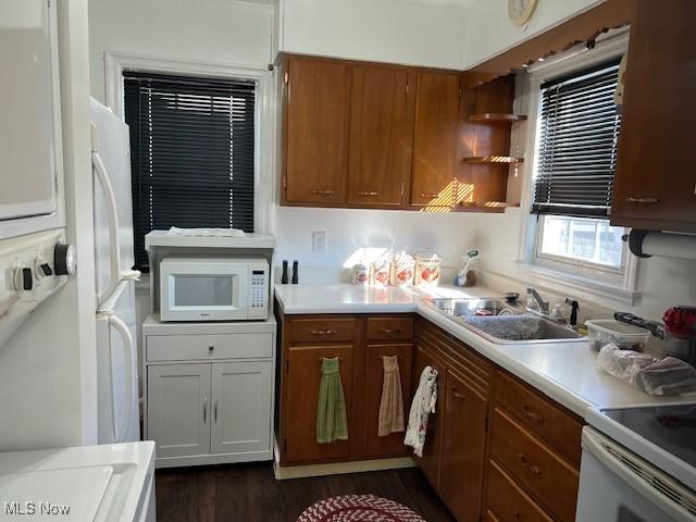 kitchen featuring dark hardwood / wood-style floors, sink, and white appliances