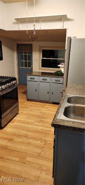 kitchen featuring sink, gray cabinets, stainless steel appliances, light hardwood / wood-style floors, and decorative light fixtures